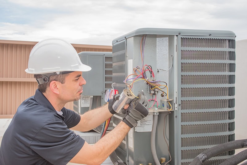 Comfort Cavalry commercial technician performing HVAC maintenance on rooftop unit in Antioch, Illinois.