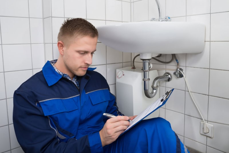 A plumber working under a sink.