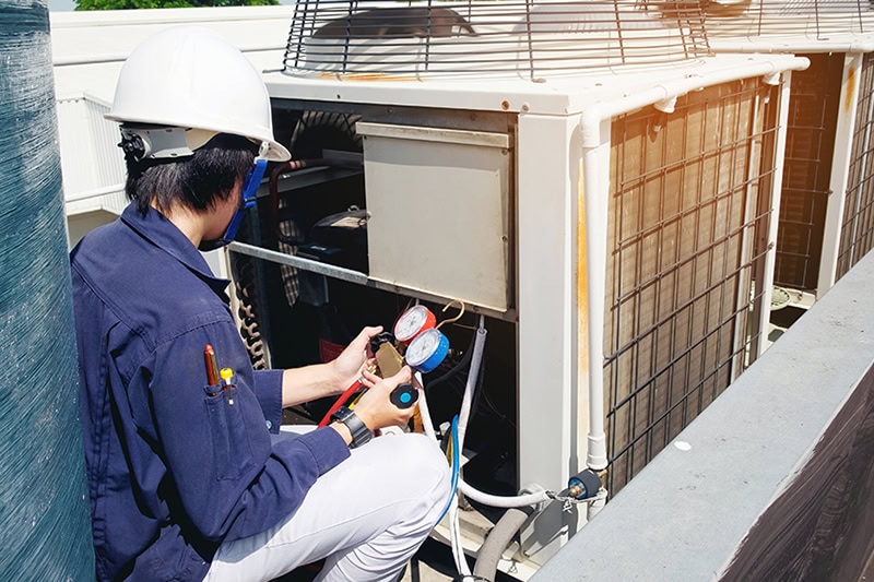 Why Is a Commercial AC Tune-Up Important? A technician working on an AC unit.